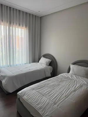 a bedroom with two beds and a window at Résidence haut standing Piscine Fitness Marrakech in Marrakech