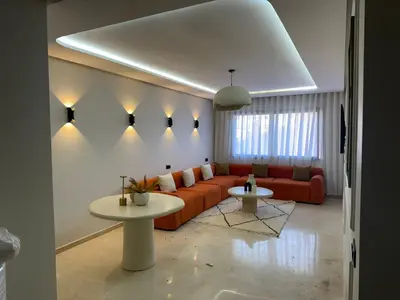 a living room with a couch and a table at Résidence haut standing Piscine Fitness Marrakech in Marrakech