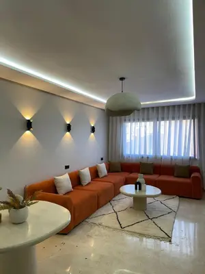 a living room with a couch and a table at Résidence haut standing Piscine Fitness Marrakech in Marrakech