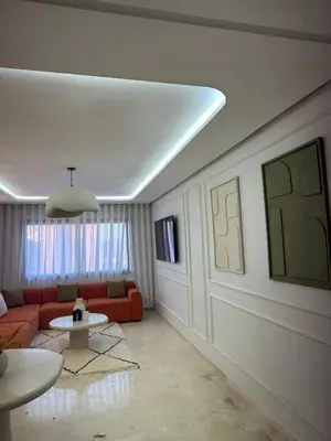 a living room with a red couch and a table at Résidence haut standing Piscine Fitness Marrakech in Marrakech