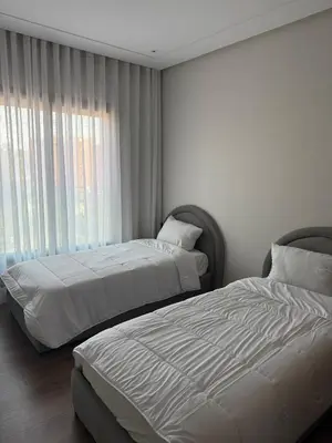 a bedroom with two beds and a window at Résidence haut standing Piscine Fitness Marrakech in Marrakech
