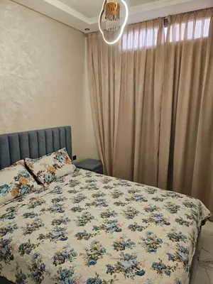a bedroom with a bed with a floral bedspread at مراكش in Marrakech