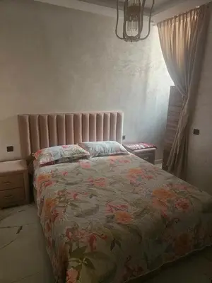 a bedroom with a bed with a floral bedspread at مراكش in Marrakech