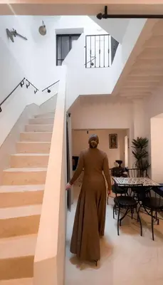 a woman walking up a staircase in a house at Stunning penthouse in city center in Marrakech