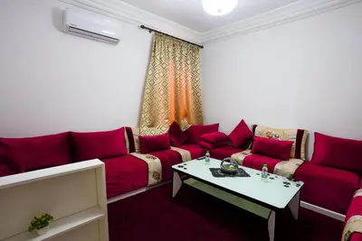 a living room with red couches and a table at apartment in Hay mabrouka gueliz Marrakech in Marrakech