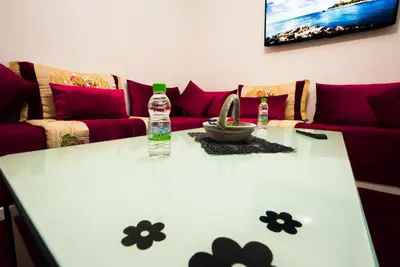 a living room with a couch and a bottle of water on a table at apartment in Hay mabrouka gueliz Marrakech in Marrakech