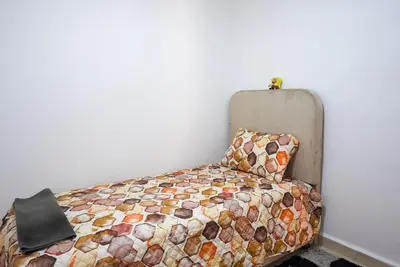 a bed in a room with a pillow next to a wall at apartment in Hay mabrouka gueliz Marrakech in Marrakech