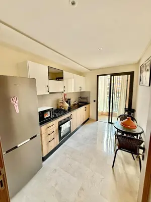 a kitchen with a refrigerator and a table in it at Stylish and cozy accommodation for families in Marrakech