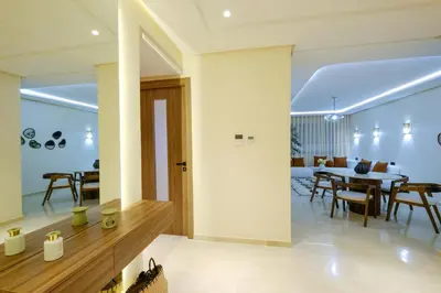 a dining room and living room with a table and chairs at Appartement vacances famille Marrakech in Marrakech