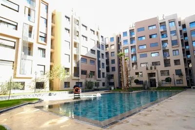 a swimming pool in front of some apartment buildings at Appartement vacances famille Marrakech in Marrakech