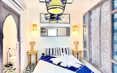 a bedroom with a bed and a chandelier at Riad Mtiwel in Marrakech