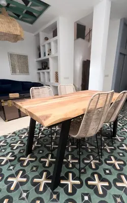 a dining room table with chairs on a green rug at Riad Mtiwel in Marrakech