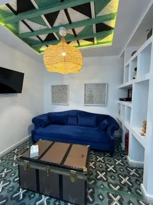 a living room with a blue couch and a table at Riad Mtiwel in Marrakech