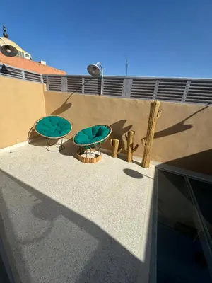 two green tables sitting on the side of a building at Riad Mtiwel in Marrakech