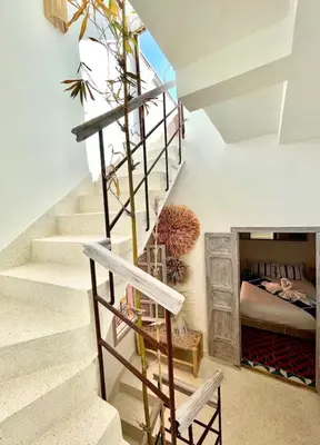 a staircase in a house with a bed in the background at Riad Mtiwel in Marrakech
