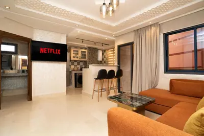 a living room with a couch and a kitchen at Gueliz Stay in Marrakech
