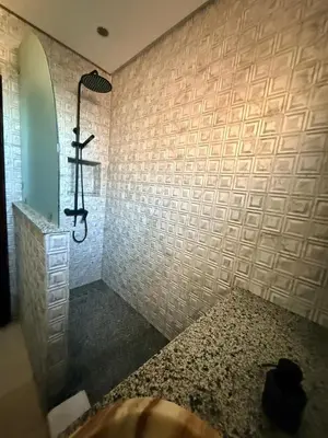 a bathroom with a shower with white tile walls at Gueliz Stay in Marrakech