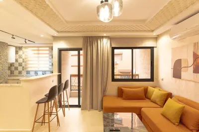 a living room with a couch and a kitchen at Gueliz Stay in Marrakech