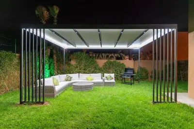 a living area with a white couch in the grass at Luxury Villa with Breakfast & Padel Access in Marrakech