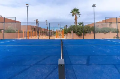 a tennis court with a net on top of it at Luxury Villa with Breakfast & Padel Access in Marrakech