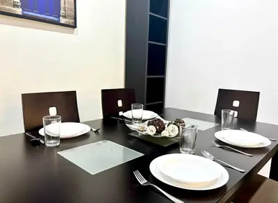 a black table with plates and a bowl of food on it at Cozy 2-bedroom apartment & pool & wifi in Marrakech