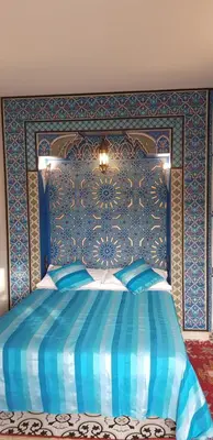 a blue bedroom with a bed with a blue wall at Riad Konouz in Marrakech