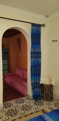 a living room with a bed and a curtain at Riad Konouz in Marrakech