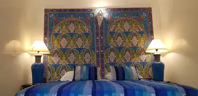 a bedroom with a blue bed with two lamps at Riad Konouz in Marrakech