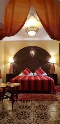 a bedroom with a bed and a chandelier at Riad Konouz in Marrakech