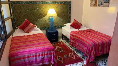 a room with two beds and a lamp in it at Riad Konouz in Marrakech