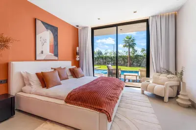 a bedroom with a bed and a view of a pool at VILLA Twenty six 1600m2 Marrakech LUXE & PROXIMITÉ in Marrakech