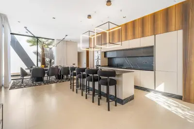 a kitchen with a bar with black chairs at VILLA Twenty six 1600m2 Marrakech LUXE & PROXIMITÉ in Marrakech