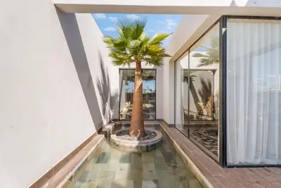 a palm tree in the middle of a house at VILLA Twenty six 1600m2 Marrakech LUXE & PROXIMITÉ in Marrakech