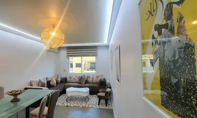 a living room with a couch and a table at Élégant et calme, à 2 minutes des meilleurs restaurants in Marrakech