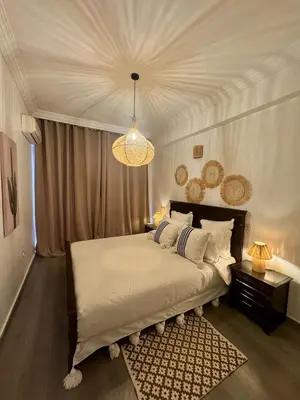 a bedroom with a large bed and a chandelier at Élégant et calme, à 2 minutes des meilleurs restaurants in Marrakech