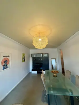 a dining room with a table and a chandelier at Élégant et calme, à 2 minutes des meilleurs restaurants in Marrakech