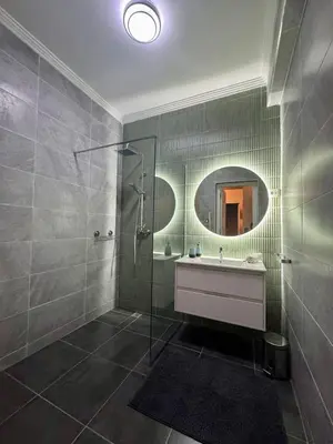 a bathroom with a shower and a sink and a mirror at Élégant et calme, à 2 minutes des meilleurs restaurants in Marrakech