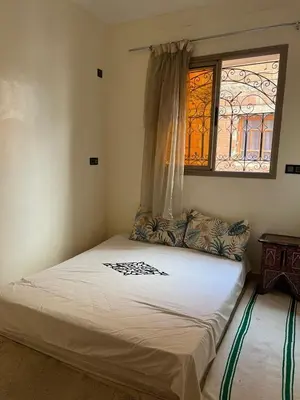a small bedroom with a bed with a window at modern apartment, 10 minutes from the airport in Oulad Akkou