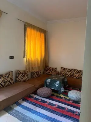 a living room with a couch with a bag on it at modern apartment, 10 minutes from the airport in Oulad Akkou
