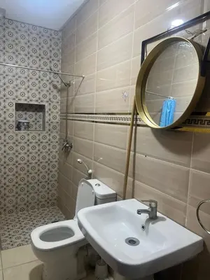 a bathroom with a toilet and a sink and a mirror at modern apartment, 10 minutes from the airport in Oulad Akkou