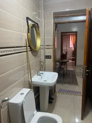 a bathroom with a sink and a toilet and a mirror at modern apartment, 10 minutes from the airport in Oulad Akkou