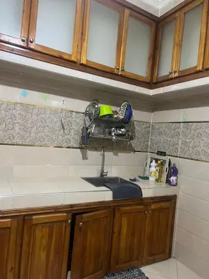 a kitchen with wooden cabinets and a sink at modern apartment, 10 minutes from the airport in Oulad Akkou