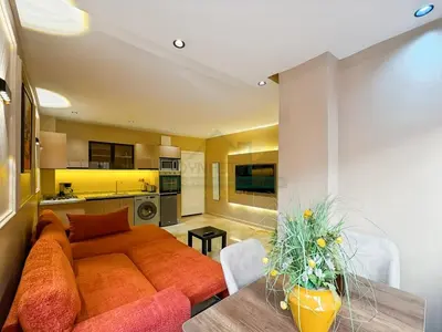 a living room with a couch and a table at Appartement neuf et chic Proche gare et CTM in Marrakech