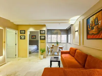 a living room with a couch and a table at Appartement neuf et chic Proche gare et CTM in Marrakech