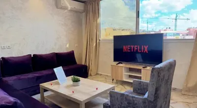 a living room with a couch and a tv at Appartement cozy in Marrakech