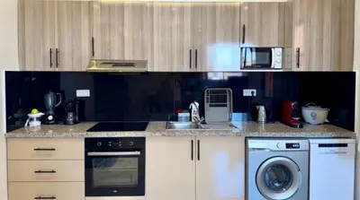 a kitchen with a stove top oven and a dishwasher at Appartement cozy in Marrakech