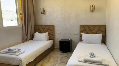 two beds sitting next to each other in a room at Appartement cozy in Marrakech