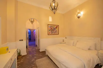 a bedroom with a white bed and a hallway at Mumtaz Dar in Marrakech