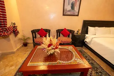 a room with a bed and a table and chairs at Mumtaz Dar in Marrakech