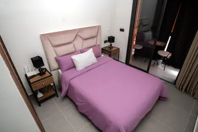 a bedroom with a purple bed and a mirror at Oasis Urban & Balcon - 5 min de l'aeroport in Marrakech